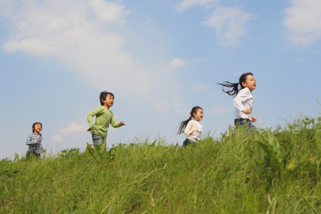 野原を駆け回る子ども