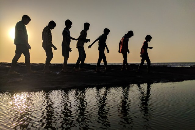 海辺で手をつなぐ子どもたち