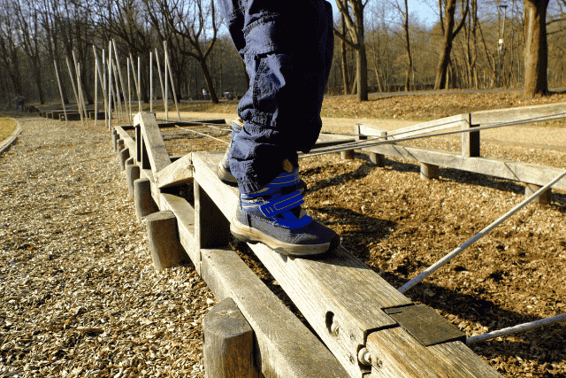 平均台のような遊具で遊ぶ子供の足元