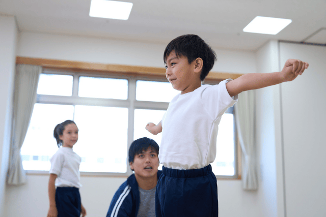 腕を伸ばす男の子