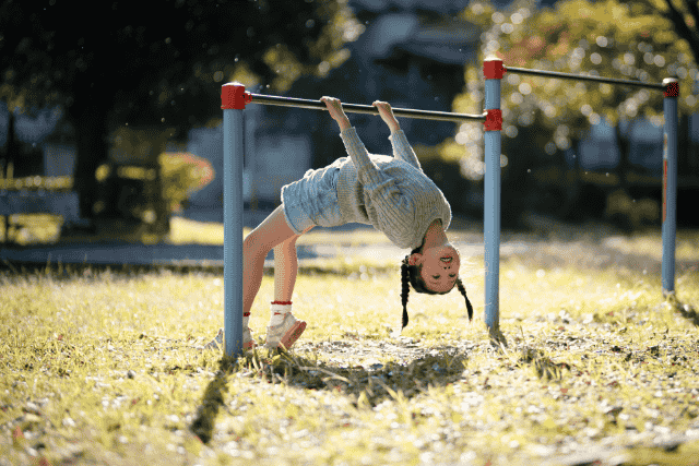 鉄棒にぶら下がる女の子