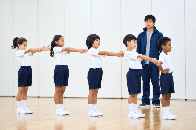 前ならえをする小学生