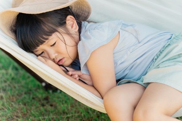 麦わら帽子をかぶって寝ている女の子