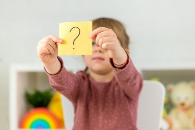 ？と書かれたメモを持つ子ども