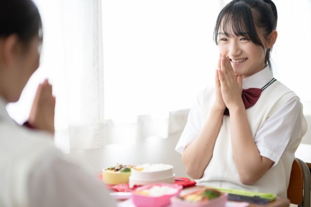 友達と昼食を食べている女子中学生