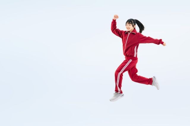 赤ジャージを着てジャンプしている女子中学生