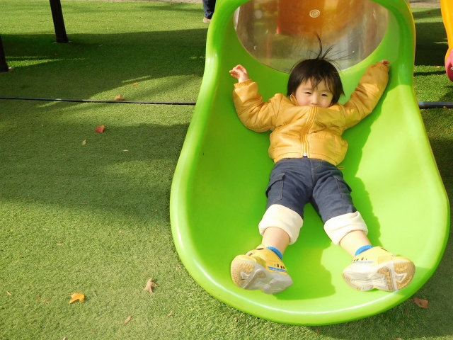 滑り台に寝そべる子ども