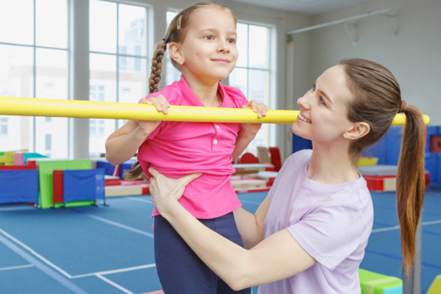 鉄棒の前回りを練習する子ども