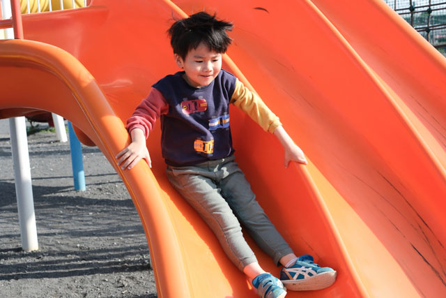 滑り台を滑る男の子