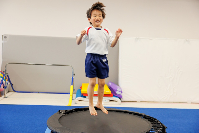 トランポリンで跳ねている男の子