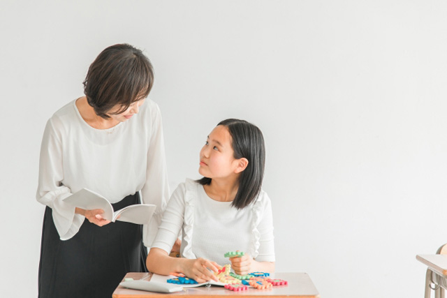 先生に教えてもらっている女の子