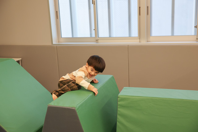 大きなブロックを乗り越えようとしている男の子