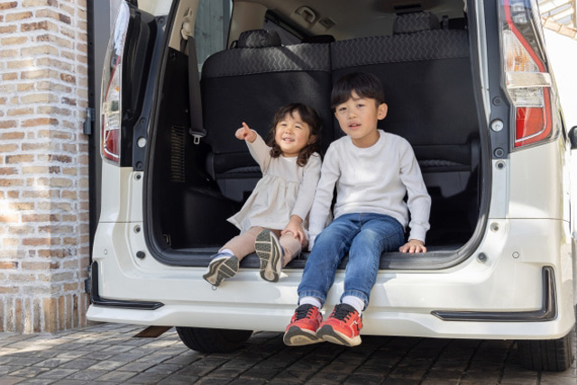 車のトランクに座っている男の子と女の子