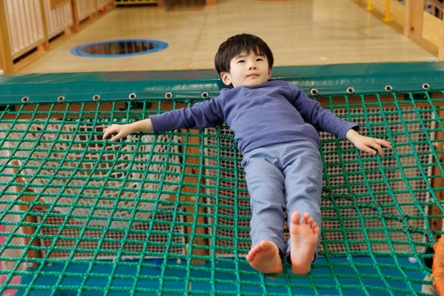 ネットの上で寝っ転がっている男の子