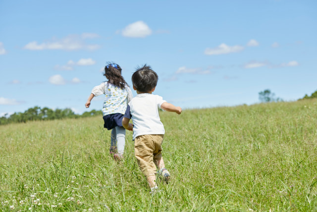 草原で走る子ども二人