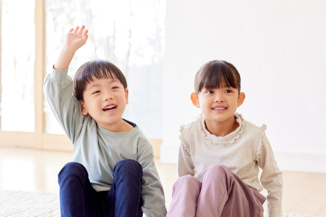 手をあげる男の子と女の子